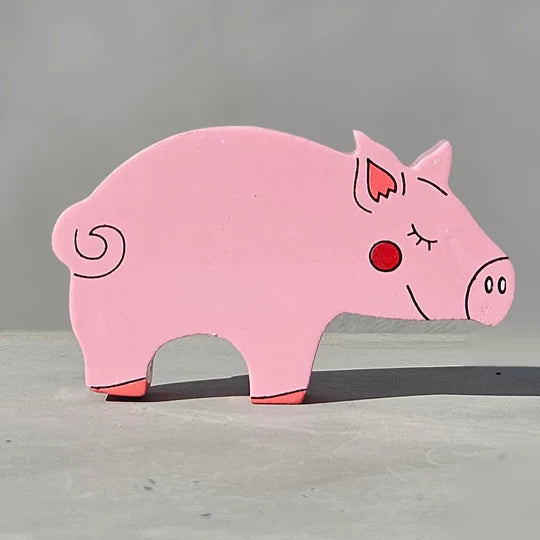 A Magnetic Wooden Pig Play Figure is sitting on a gray surface.