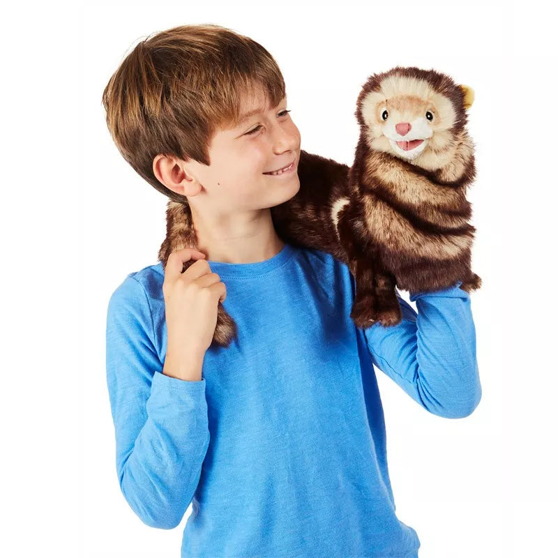 A young boy holding a Folkmanis Puppets Ferret.