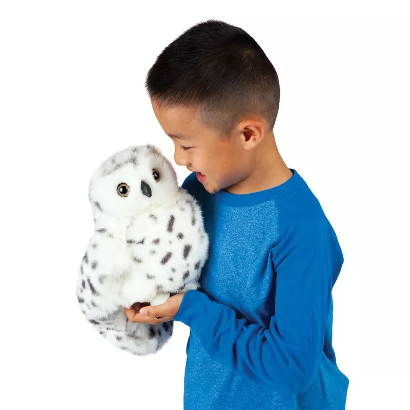 A young boy holding a Folkmanis Puppets Snowy Owl.