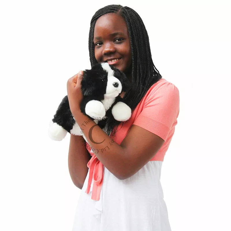 A young girl holding The Puppet Company Full-bodied Hand Puppet Border Collie.