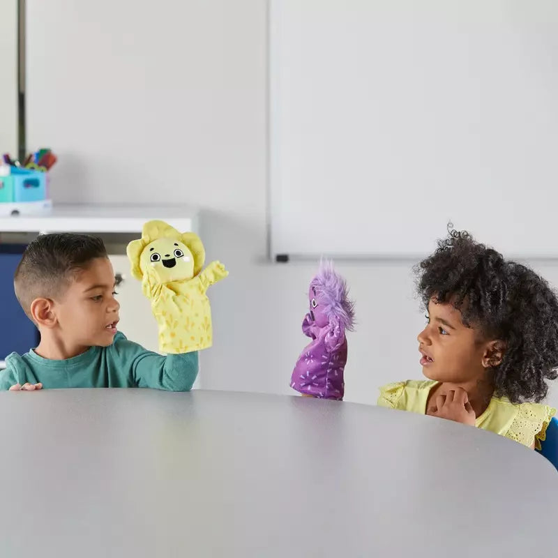 Two children playing with Learning Resources Feelings Family™ Hand Puppets at a table.