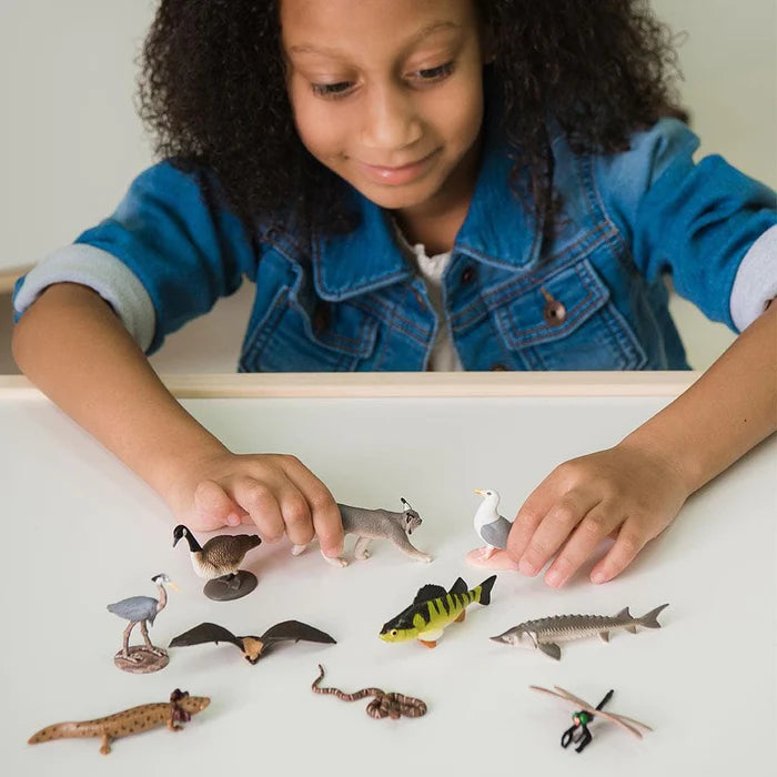 A girl is performing a puppet show with a set of TOOBS® Figurines Great Lakes.