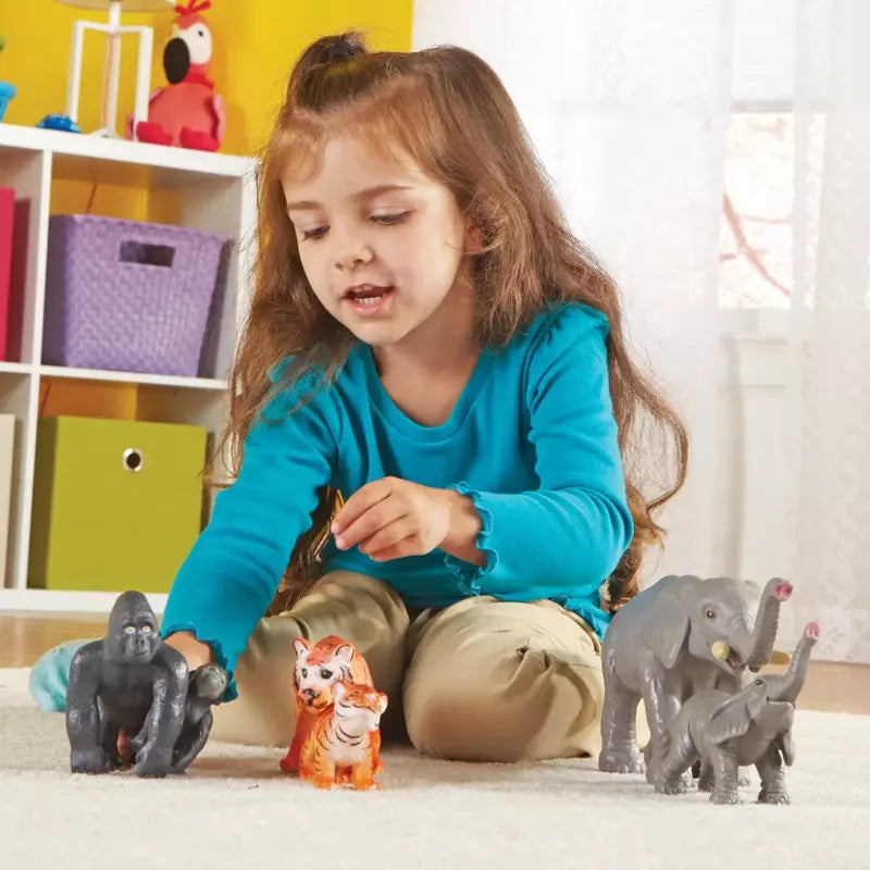 A toddler playing with a set of durable Learning Resources Jumbo Jungle Animals - Mommas And Babies on the floor.